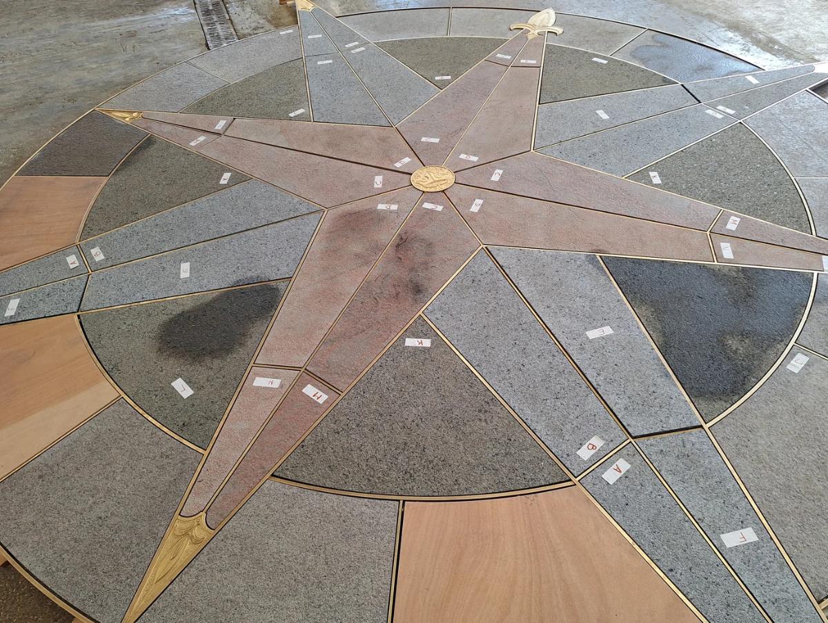 The new compass rose for the bridge, with each stone piece labelled during assembly